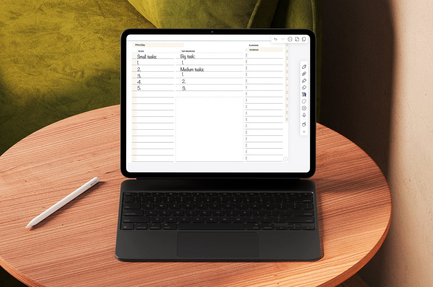 An iPad with a digital planner on the screen and a keyboard propped up on a small, wooden table with an Apple Pencil sitting next to it.