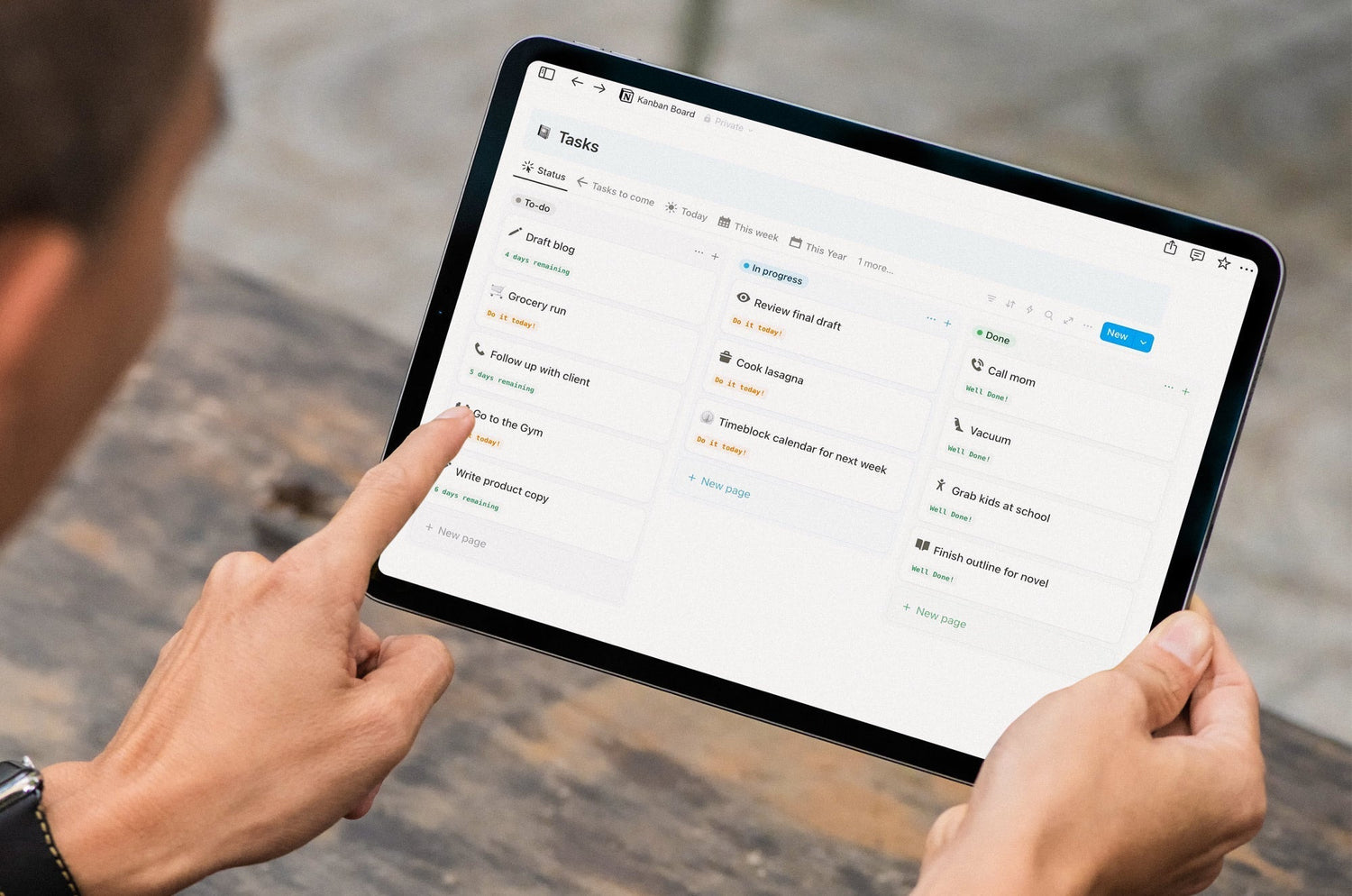 Person using a tablet with a digital Kanban board app to organize tasks into to-do, in-progress, and done columns.