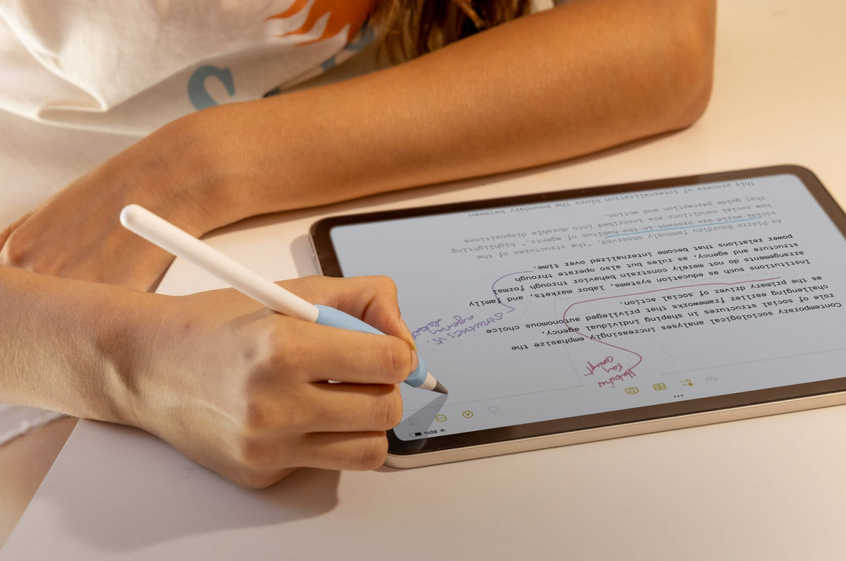 A person taking notes on an iPad with an Apple Pencil.