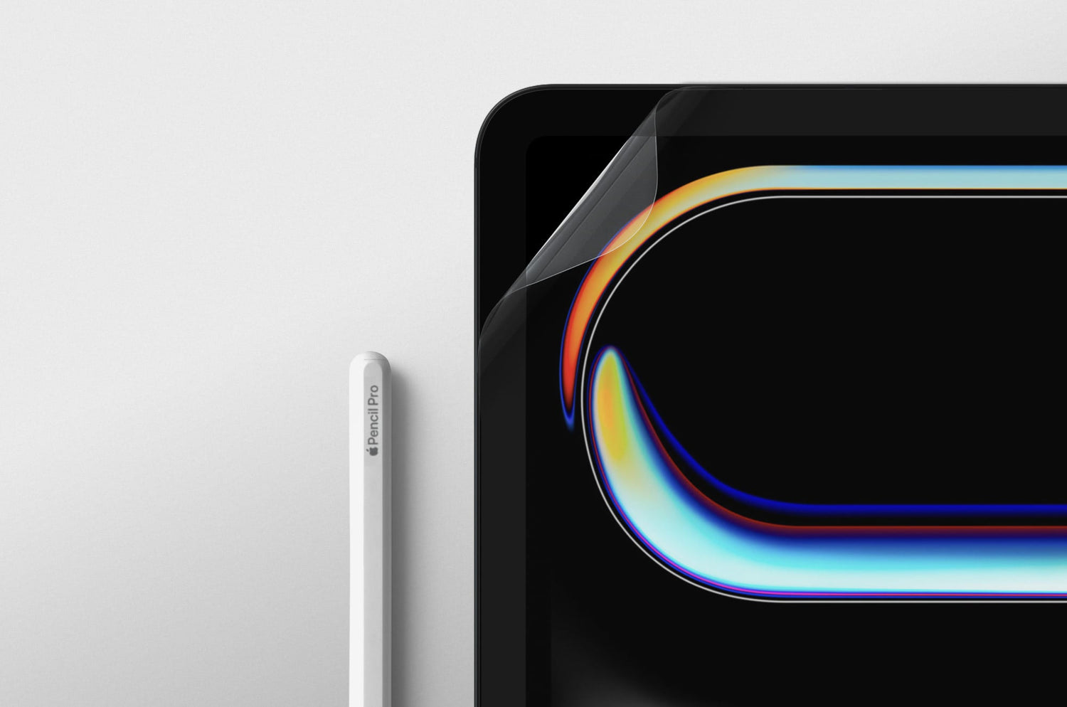 The corner of an iPad with a screen protector peeling up from the corner. An Apple Pencil sits next to the iPad.