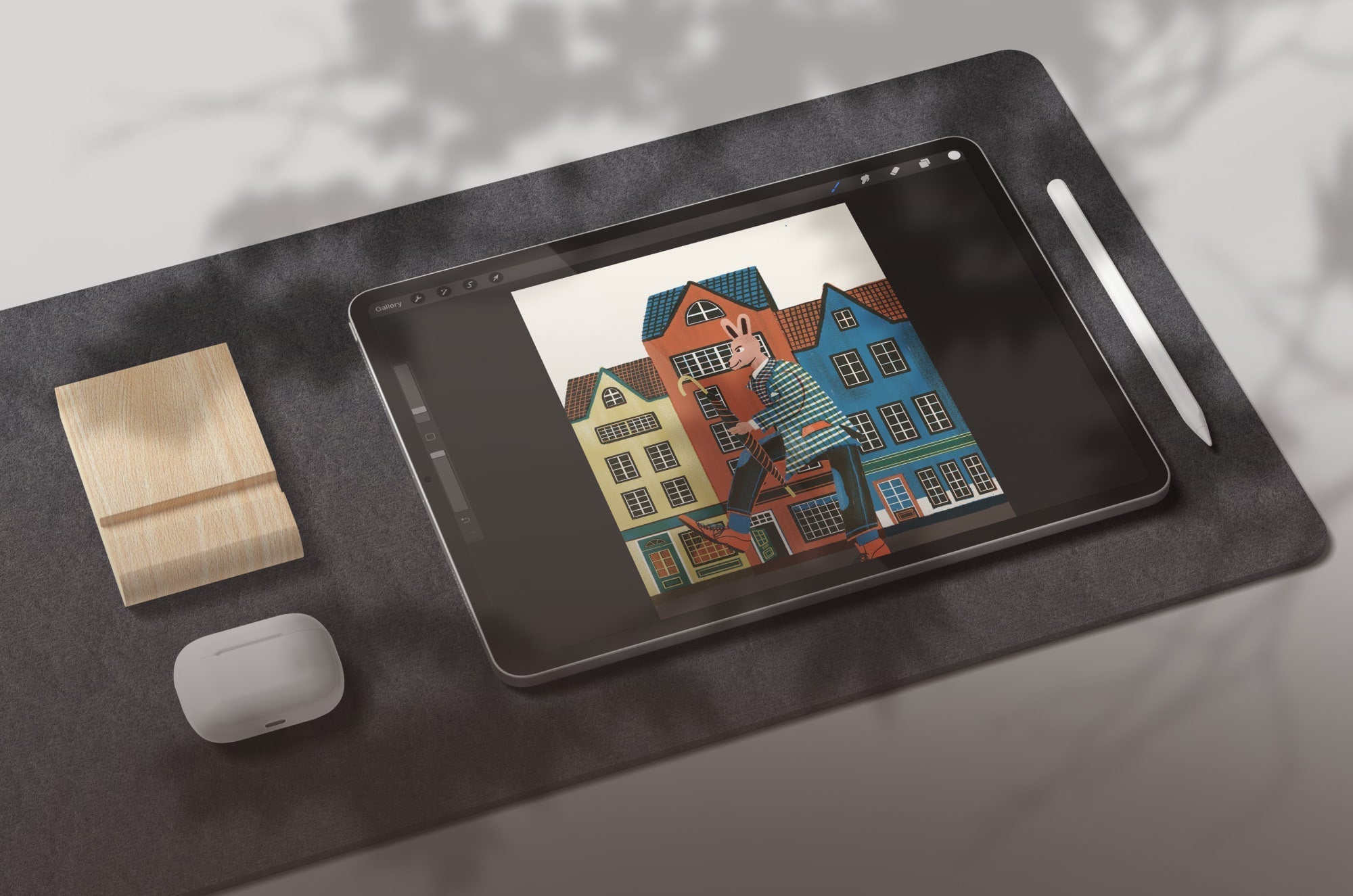 An iPad with Procreate open on it, sitting on a pad with an Apple Pencil and Apple AirPods beside it.