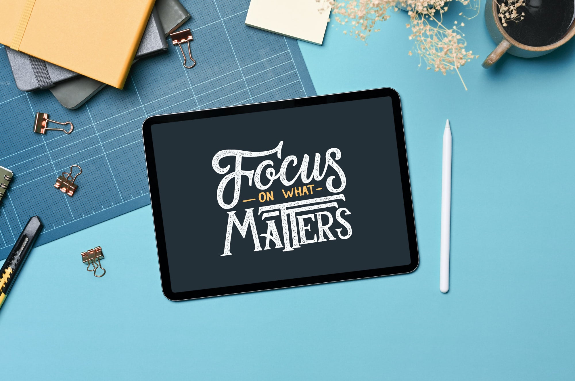 An image of an iPad surrounded by stationery supplies and an Apple Pencil with lettering that says, "Focus on what matters".