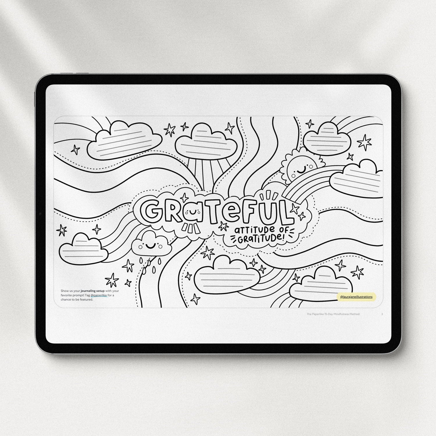 Tablet displaying a black-and-white coloring page from 'The Paperlike 15-Day Mindfulness Method'. The page features the word 'Grateful' surrounded by cheerful illustrations of clouds, stars, rainbows, and the phrase 'Attitude of Gratitude' in a playful, doodle style.