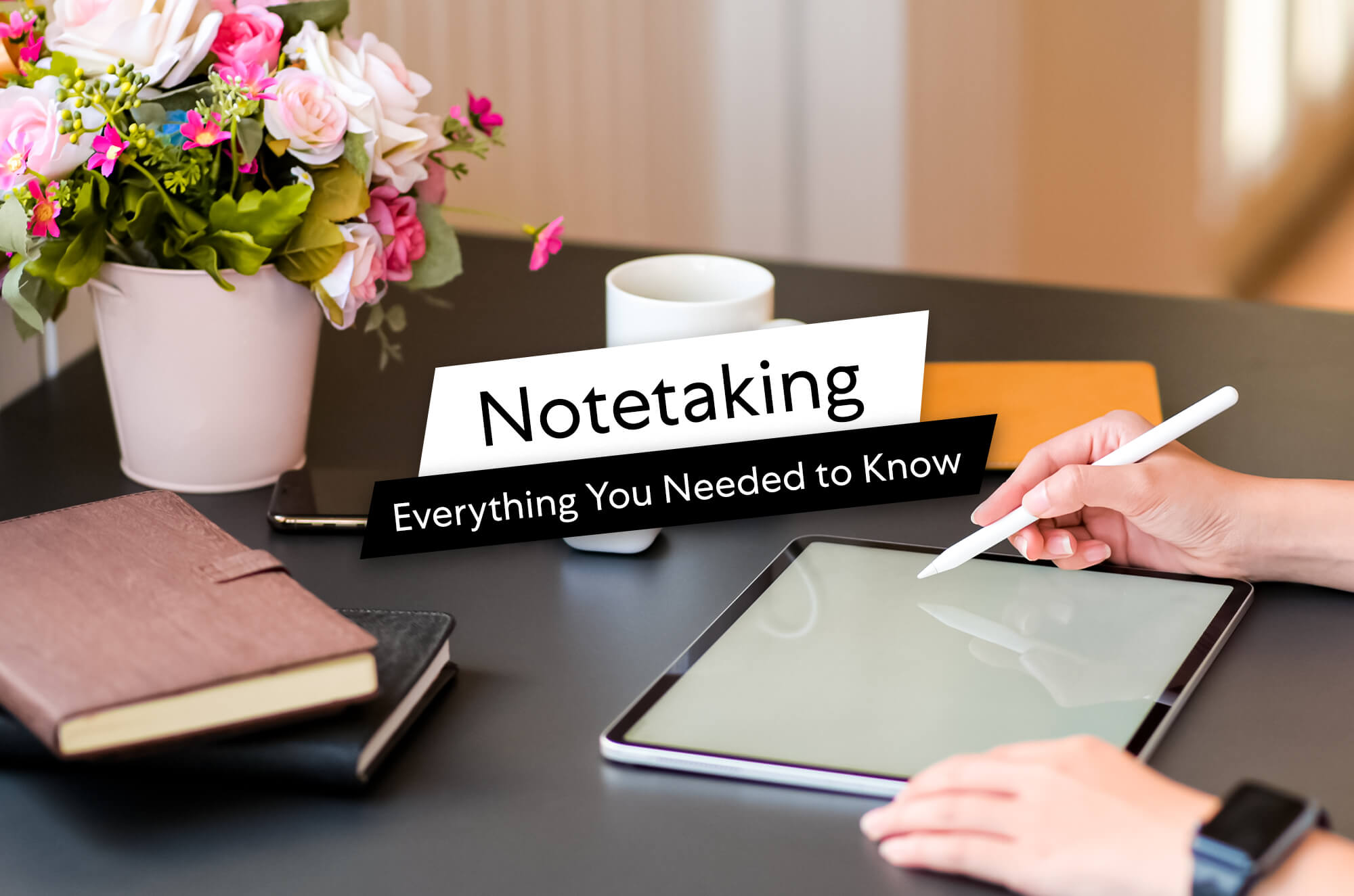 Person using Apple Pencil on iPad with headline text ‘Notetaking: Everything You Needed to Know’ on screen, next to notebooks, coffee cup, and flowers on a desk.