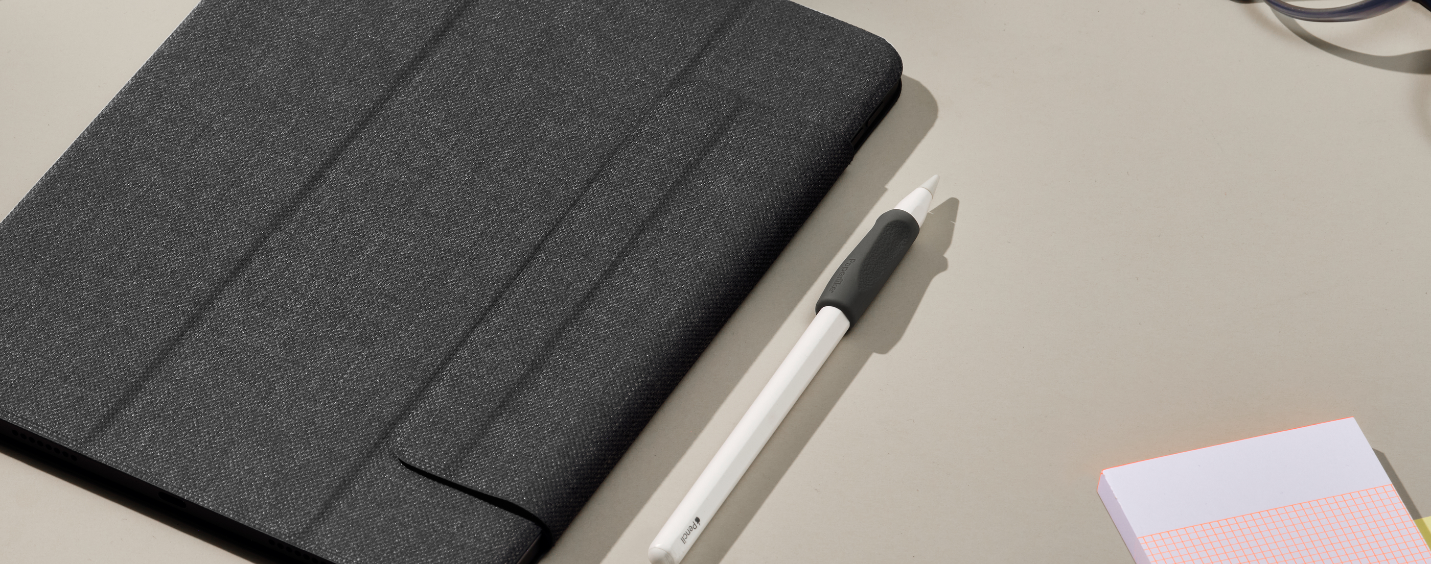 Close up image of iPad with Paperlike folio case, Apple Pencil with charcoal pencil grip