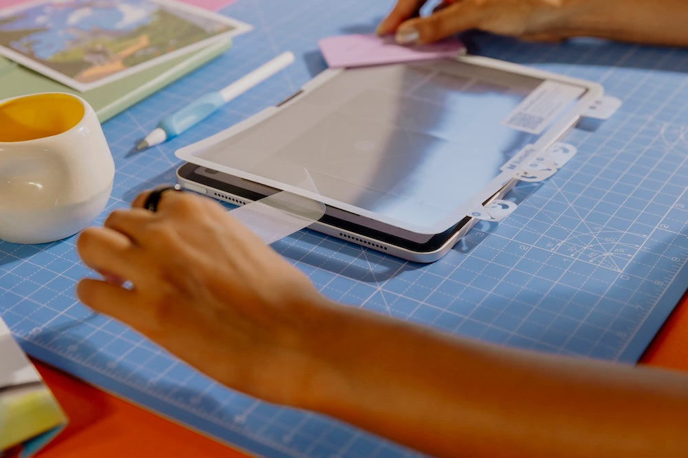 Person removing an inner layer of the screen protector to create the clean room effect.