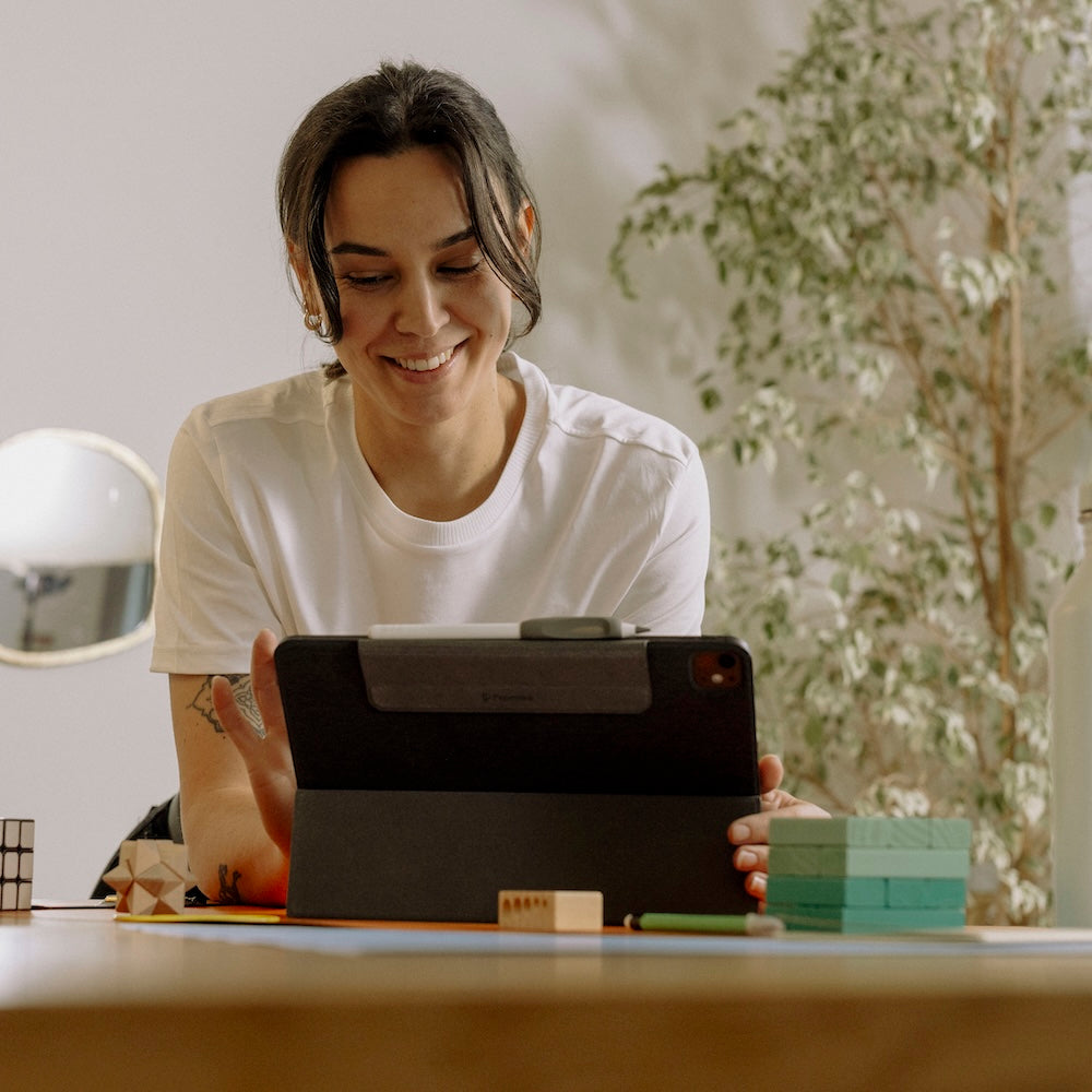 Person working on an iPad, smiling, having fun.
