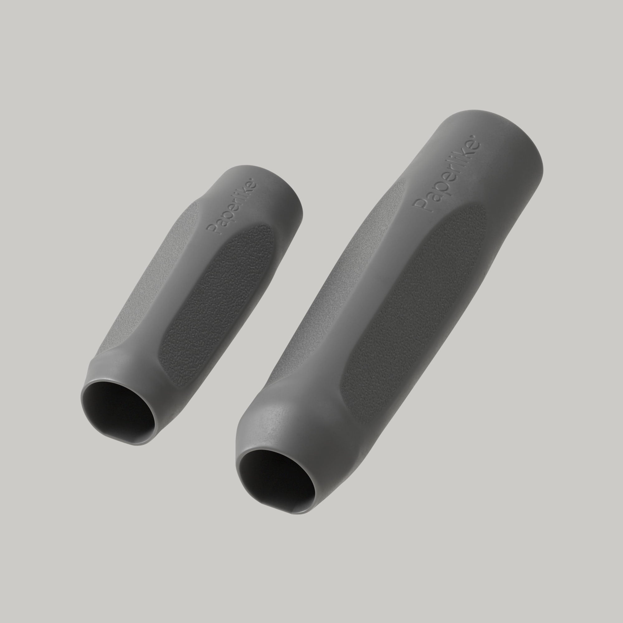 A Maximum Comfort Grip and a Maximum Precision Grip, both part of Paperlike’s Pencil Grips set, both in charcoal gray, sit next to each other.